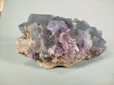 a purple crystal on top of a rock on a table