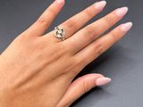 the woman ' s hand is holding a yellow and white diamond ring