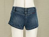 denim shorts on a mannequin stand with a white mannequin in front of a curtain