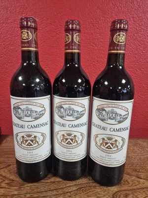 trois bouteilles de vin posées sur une table en bois
