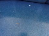 a blue couch that has a black spot on it