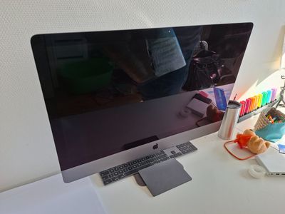 a computer monitor sitting on a desk with a keyboard and mouse