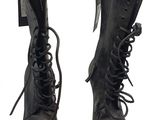 une paire de bottes en cuir noir à lacets, avec une étiquette sur fond blanc