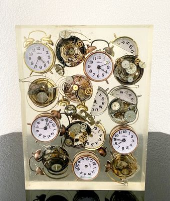 many different types of clocks displayed in a display case
