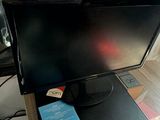 a computer monitor sitting on top of a desk next to a keyboard