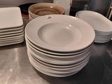 a lot of white plates and bowls on the counter