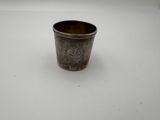 une vieille coupe en argent portant un monogramme sur un fond blanc