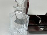 a clear glass bottle with a tag on it sitting on a table