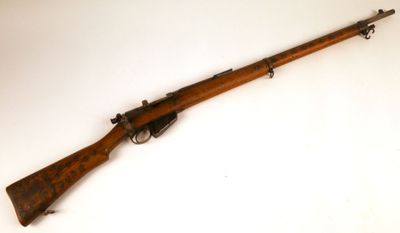 un vieux fusil avec un canon en bois et une poignée en bois