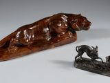 deux figurines en bronze représentant un chien et un homme sur un traîneau