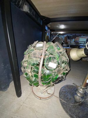 une boule de verre verte posée par terre à côté d'un poteau métallique