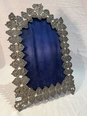 un cadre en argent richement décoré, recouvert de velours bleu