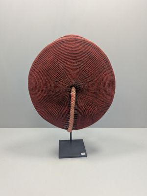 a close up of a red basket on a metal stand