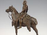bronze statue of a man on a horse on a wooden base