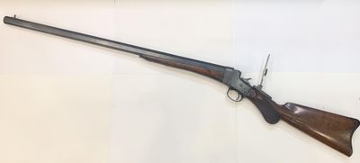 a rifle with a wooden barrel on display in a glass case