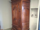 a tall wooden cabinet in a room with a green floor