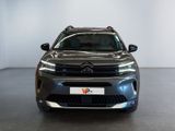 the front view of a grey suv parked in a showroom