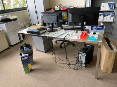 un bureau sur lequel se trouvent deux écrans et une imprimante