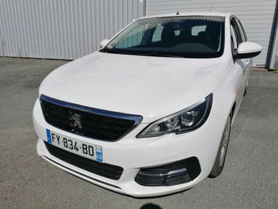 la voiture blanche est garée devant un bâtiment