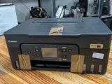 a canon printer sitting on a wooden table in a room