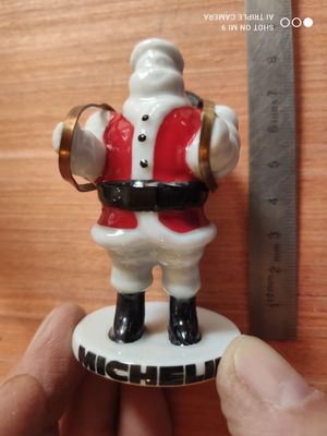 une petite figurine représentant le Père Noël tenant une clochette
