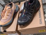 two pairs of hiking shoes sitting on top of a cardboard box