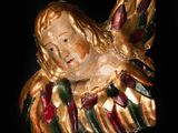 an image of a gold angel ornament on a black background