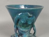 un vase bleu orné d'une statue représentant un homme
