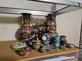 de nombreux vases et bols posés sur une étagère dans une pièce