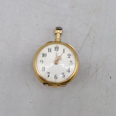 une image d'une montre de poche en or sur une surface blanche
