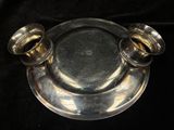 a silver plate with two silver cups on it
