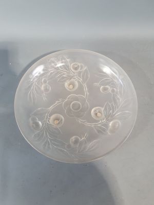 un bol en verre transparent orné de fleurs, posé sur une table