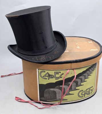 un haut-de-forme noir posé sur une boîte en carton