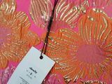a close up of a pink shirt with gold flowers on it