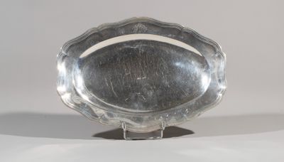 a silver plate on a stand on a white surface