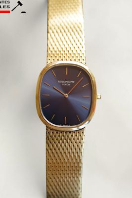 un gros plan d'une montre-bracelet en or avec un cadran bleu