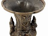a bronze vase that is sitting on a table