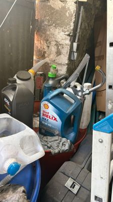 un seau bleu rempli de produits d'entretien dans un garage