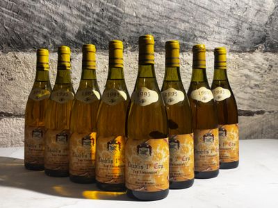 six bottles of wine are lined up in a row in front of a stone wall