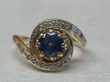 une photo d'une bague sertie d'un saphir bleu et de diamants