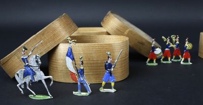 Plusieurs figurines représentant des hommes en uniforme militaire sont exposées dans une boîte en bois