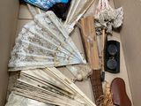 a cardboard box filled with assorted items like umbrellas, hats, and other items