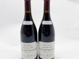 deux bouteilles de vin rouge posées l'une à côté de l'autre sur une surface blanche