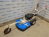 an image of a small lawn mower parked in a garage
