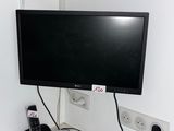 une télévision et un téléphone posés sur un bureau dans une pièce