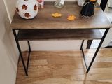 a wooden table with a vase and a picture on it