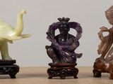 three figurines of elephants and a woman on a table