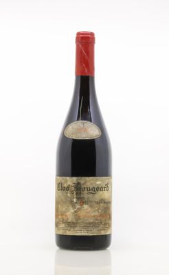 une vieille bouteille de vin rouge posée sur une table blanche