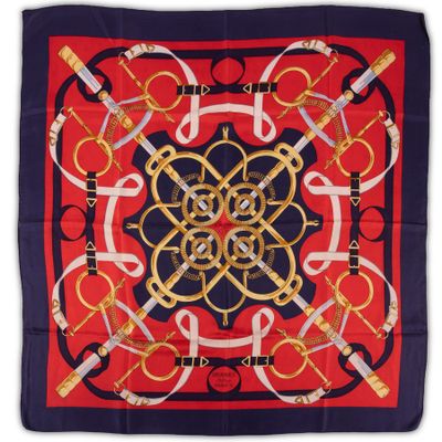 a close up of a red and blue square scarf with a gold and black design