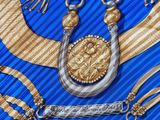 a blue and gold cloth with gold and silver items on it
